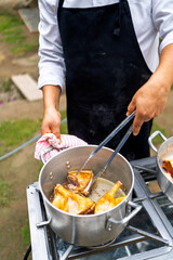 Chef preparing food outdoors for country restaurant