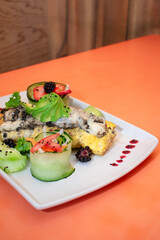 Plato saludable para desayuno con omelette y ensalada verde con frutas