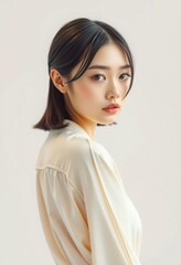 Portrait of a Calm Thai Woman with Shoulder-Length Hair in Cream Blouse.