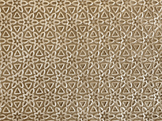 Close up of geometrical flower shape pattern cutouts in metallic gold paint finish. 3D cutout laser cut floral shapes suitable for screens or divider. Seamless background texture.