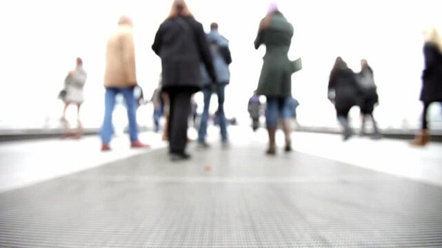 Abstract People. Defocused in-camera footage of people walking candidly around the camera in a bleached futuristic landscape.