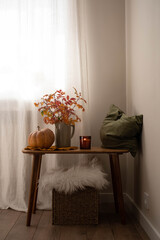 cozy autumn scene, autumn harvest in cozy setting, warm autumn interior with pumpkins, pillow, autumn leaves and candles on wooden bench. hallown consept.