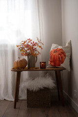 cozy autumn scene, autumn harvest in cozy setting, warm autumn interior with pumpkins, pillow, autumn leaves and candles on wooden bench. hallown consept.