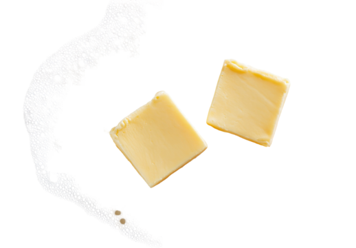 Two butter squares on a black background with a white splatter