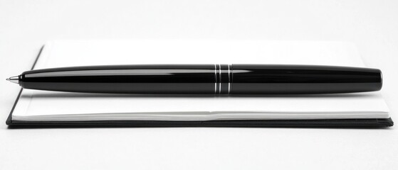 Sleek black pen on closed notebook office supplies writing business concept