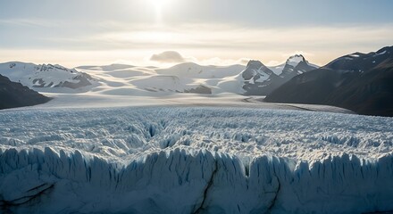 Panoramic view of a massive glacier with rugged mountains under a bright sky.