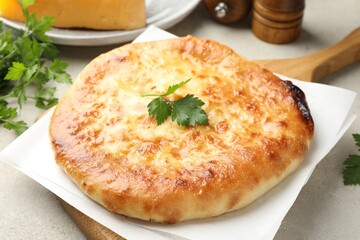 Delicious Megrelian khachapuri with ingredients on grey table, closeup