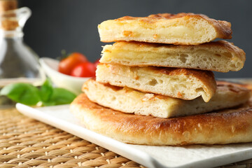Pieces of delicious Megrelian khachapuri on table, closeup