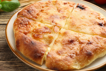 Delicious Megrelian khachapuri on wooden table, closeup