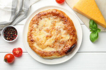 Delicious Megrelian khachapuri and products on white wooden table, flat lay