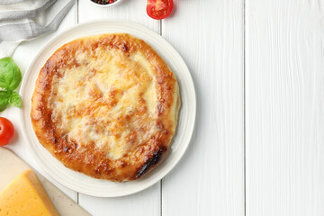 Delicious Megrelian khachapuri and products on white wooden table, flat lay. Space for text