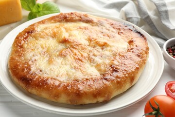 Delicious Megrelian khachapuri and products on white wooden table, closeup