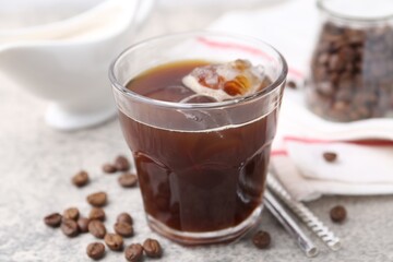 Tasty iced coffee and beans on light table, closeup