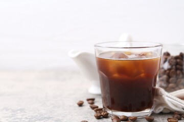 Tasty iced coffee and beans on light table, closeup. Space for text