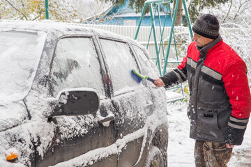 Russia. A 49-year-old man clears snow from a car window.