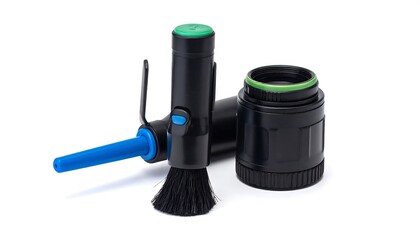 Photo gear black lens, cleaning brush, and blower against white background. Clean and simple composition