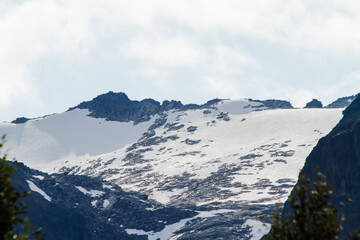 Close-up of a snow-covered mountain ridge under a cloudy sky, natural landscape