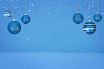 Christmas tree baubles on blue background with white snow. Festive winter holiday background. Design with copy space for greeting card, text, advertising, banner, invitation