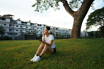 Woman relaxing in park listening to music