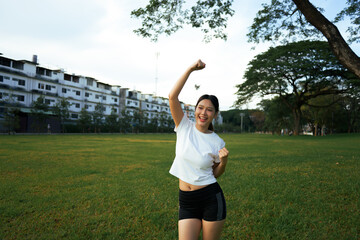 Asian woman celebrating success after outdoor park workout
