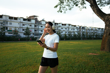 Young woman enjoying music with headphones in park