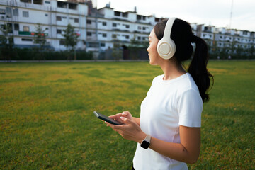 Woman relaxing in park listening to music on headphones