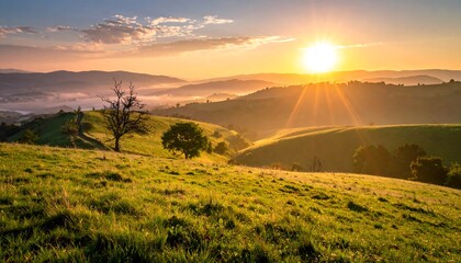 Rolling green hills bathed in golden sunlight at sunrise, with misty valleys and distant mountains