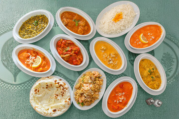 Assortiment de plats indiens – vue de dessus à 90°, cuisine traditionnelle épicée et colorée de l’Inde. La composition comprend des currys variés, riz basmati, naan, samoussas. 