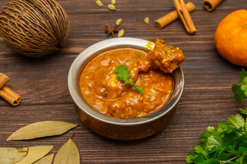 Poulet Masala – curry de poulet épicé indien servi sur une table en bois
