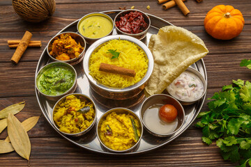 Thali indien – assortiment de plats traditionnels servi sur une table en bois. 