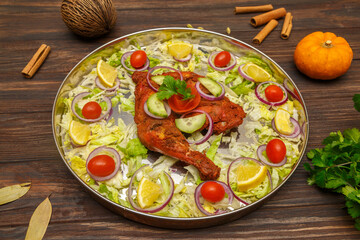 Poulet tandoori – spécialité indienne grillée au four tandoor, présenté sur une table en bois
