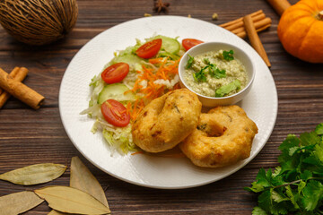 Ulundu Vadai – beignets sri-lankais aux lentilles noires, présentés sur une table en bois. Plat sri-lankais. 
