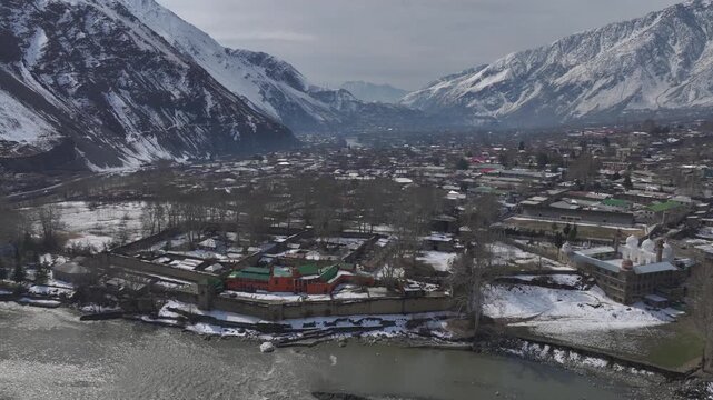 Aerial view in Winter of a historical Fort in Chitral, Pakistan. Bright building along the riverbank in Kalash Valley.