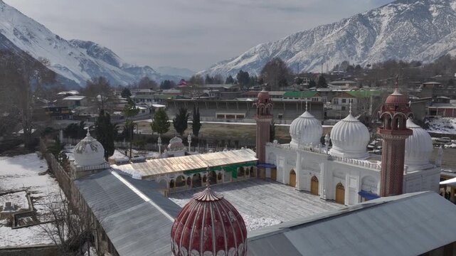 Aerial view of Chitral Central Mosque in Winter in Khyber-Pakhtunkhwa, Chitral, Pakistan. White Domes in sunny day