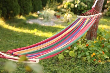 One comfortable colorful hammock hanging in garden