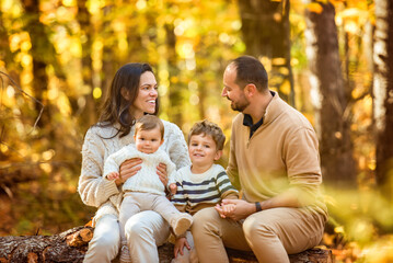Fototapeta premium Beautiful young family on a walk in autumn forest