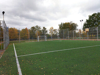 Urban soccer field with bleachers in a city park during fall