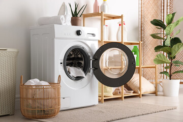 Laundry room interior with washing machine, basket, detergents and houseplants