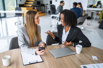 Businesswomen discussing new project in corporate office meeting