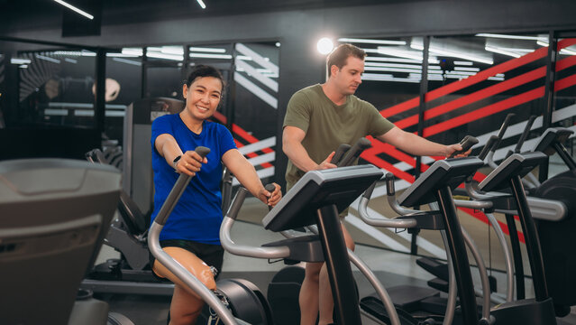 A motivated woman with a prosthetic leg walking on a treadmill in a modern gym, representing fitness, rehabilitation, and strength with a positive attitude towards an active healthy lifestyle.