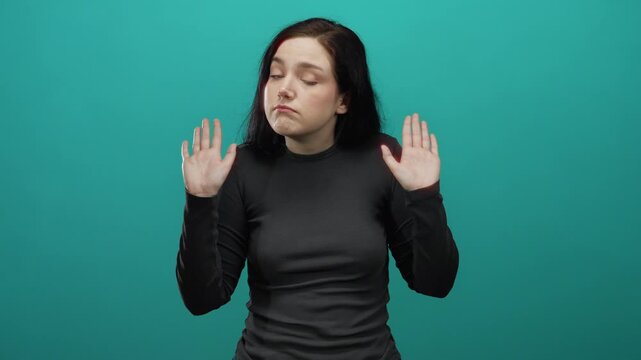 Woman brunette shrugging uncertainly against vibrant blue background emphasizing confusion and questioning with gestures.
