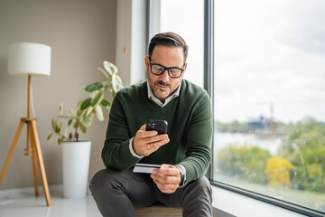 Man making secure online payment using smart phone and credit card