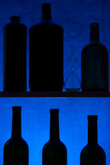 Still life with silhouettes of bottles on a blue background