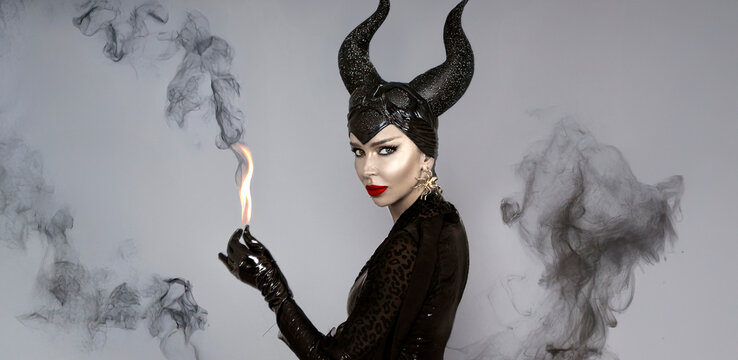 Dark queen with black horns and red lips in dramatic Halloween portrait Witch with smoke &mdash; fantasy and villain inspired look