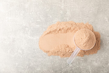 Protein powder. A spoonful of protein powder on a table. Different flavors of whey protein powder. Sports nutrition concept. Gym. Amino acid food supplement, creatine powder. Copy space.