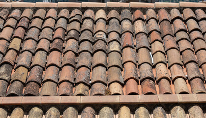 Rustic clay tiles on a sloped roof  weathered texture  european  surface