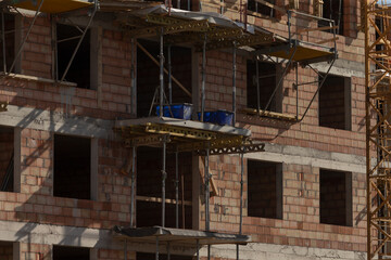 construction in progress, ongoing construction site activity, site actively under construction with cranes and scaffolding, construction activities are actively progressing with cranes and scaffolding