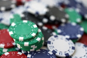 Close up of a group of casino chips on a green mat for poker or dice games indoors