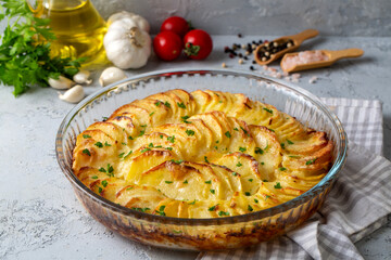 Potato gratin - graten (baked potatoes with cream and cheese) with rosemary and forks (Turkish name; Kremali patates)
