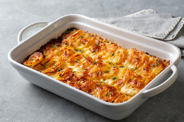 Potato gratin - graten (baked potatoes with cream and cheese) with rosemary and forks (Turkish name; Kremali patates)